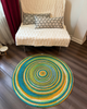 Colorful round jute rug with concentric design. Hand-braided, reversible, and eco-friendly area rug.