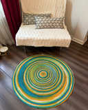 Colorful round jute rug with concentric design. Hand-braided, reversible, and eco-friendly area rug.